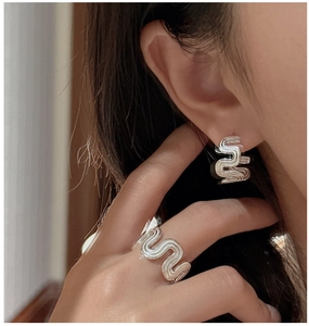 Detailed macro shot of wavy textured S925 silver ring and matching earrings set