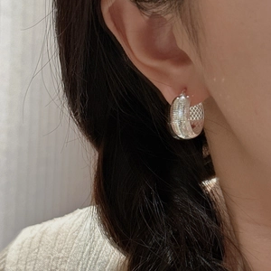 Boucles d'oreilles créoles en argent S925 avec motif CNC porté par un modèle