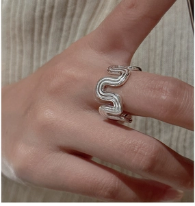Macro shot of silver S925 wavy ring featuring smooth mirror finish and minimalist design