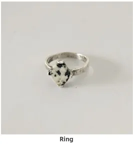Detail view of handmade hammered silver ring featuring a round Dalmatian stone inlay