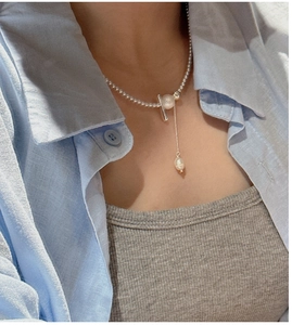 Detail of S925 silver necklace with baroque pearl pendant and OT toggle clasp on model