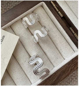 Close-up of S925 sterling silver wavy rings with vertical texture in a wood jewelry box