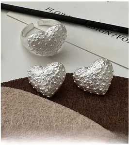 Detailed close-up of S925 sterling silver heart earrings with unique lava rock texture
