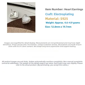 Detail of S925 sterling silver heart earrings with vintage rock texture and matte finish
