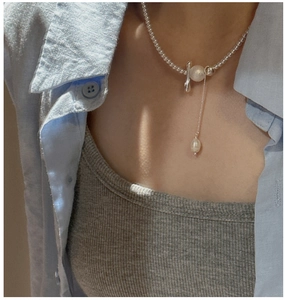 Detail of S925 silver beaded necklace with frosted pendant on model neck