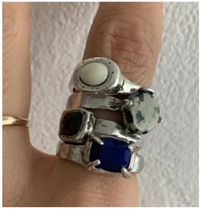 Detail of vintage silver rings set with dalmatian stone and colorful gemstones