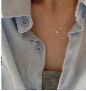 Close-up of S925 sterling silver necklace with single zircon pendant on female model