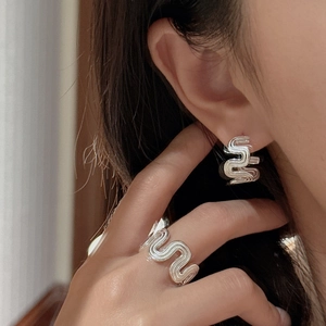 Minimalist S925 sterling silver wave ring and matching earrings set worn by a model