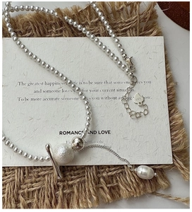 Close-up of S925 sterling silver beaded necklace with frosted bead and pearl drop pendant