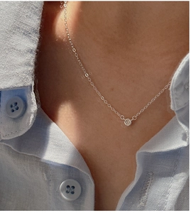 Detail of S925 sterling silver clavicle chain with a single cubic zirconia pendant