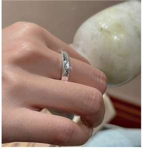 Close-up of S925 sterling silver honeycomb textured ring worn on a finger with stone prop