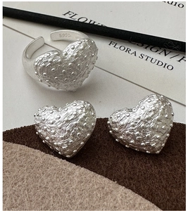 Macro detail of S925 sterling silver heart jewelry with vintage textured granules