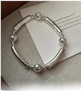 Detailed shot of S925 sterling silver watermelon bead bracelet on textured fabric