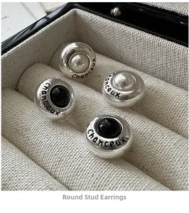 Detail of S925 sterling silver round stud earrings with Chanceux engraving and pearls