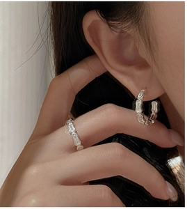 Detail of S925 sterling silver geometric link ring and C-shaped zircon earrings on model