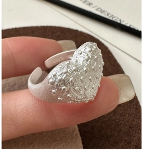 Detailed macro of S925 silver ring featuring a textured 3D heart and matte finish