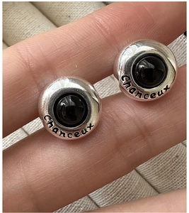 Close-up of S925 silver hoop earring with black inlay and lucky Chanceux engraving