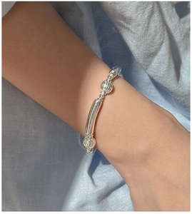 Detail of silver beaded stretch bracelet with smooth tubes and vertical striped beads