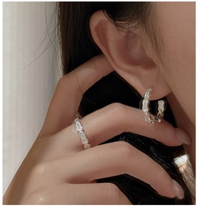 Detail of S925 silver bamboo-style ring and earring set with zircon accents on model