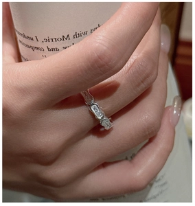 Detail of S925 silver capsule ring with pavé zircons on woman's hand holding a cup