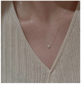 Gros plan d'un délicat collier pendentif cœur en argent sterling S925 sur un mannequin