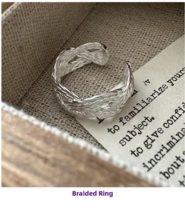Detail of S925 sterling silver woven ring inside a vintage wooden box on burlap