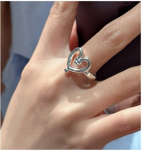 Close-up of S925 sterling silver hollow heart ring with beaded details on a model