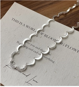 Macro detail of S925 silver crescent moon necklace links with sparkling zircon stones