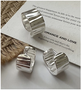 Detail view of silver S925 ring and earrings featuring unique rippled textured finish