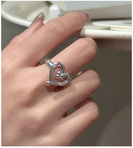 Close-up of S925 sterling silver heart ring with inner bead details on a finger