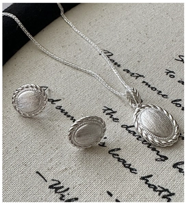 Detailed set showing brushed silver necklace and stud earrings with rope edges