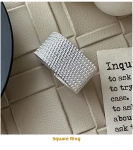 Macro detail of silver square ring featuring intricate woven mesh texture on wide band