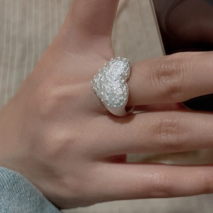 S925 sterling silver heart ring with textured granular surface on index finger