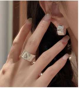 Macro detail of silver earrings and ring set with unique irregular wrinkled texture