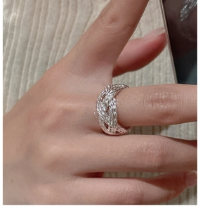 Detailed view of woven S925 sterling silver ring showing braided texture on finger
