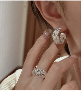 Close-up of S925 silver woven texture earrings and matching ring on model