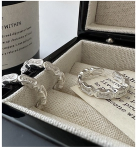 Macro shot of S925 silver link rings with zircon pavé set in a beige jewelry box