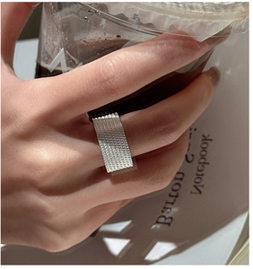 Detailed view of S925 silver square mesh woven ring on finger with aesthetic background