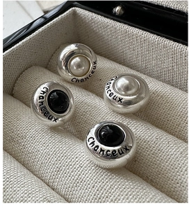 Macro view of S925 silver earrings set with pearl, black agate and lucky engraving