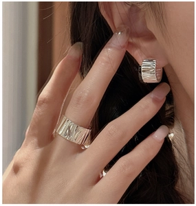 Close-up of S925 silver earrings and ring set featuring unique crumpled metal textures