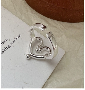 Detailed close-up of S925 sterling silver heart-shaped adjustable open ring on paper