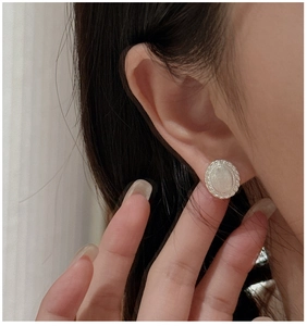 Macro shot of S925 sterling silver earring featuring vintage brushed texture and white inlay