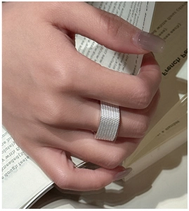 Close-up of wide silver textured mesh ring showing intricate woven metal design details
