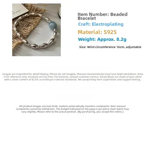 Detail of S925 sterling silver beaded bracelet with a light blue gemstone on linen