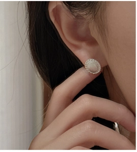 Detail of vintage oval stud earrings with brushed texture and twisted rope border