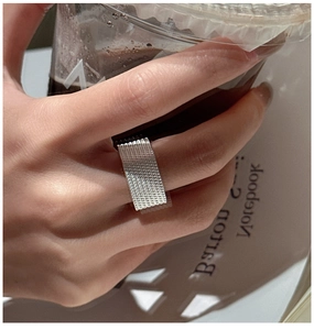 Detailed view of wide S925 sterling silver ring with woven chain texture on finger