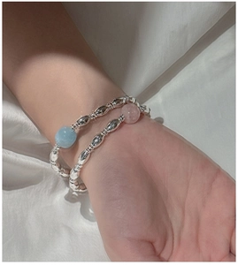 Detail of S925 silver beaded bracelets with light blue and pink beads on silk