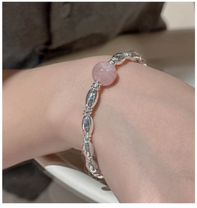 Detail of S925 sterling silver beaded bracelet with pink gemstone on model wrist