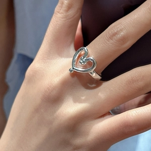 Minimalist S925 sterling silver ring featuring a hollow heart design on a finger
