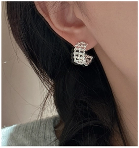 Close-up of S925 sterling silver woven mesh hoop earring on model side profile